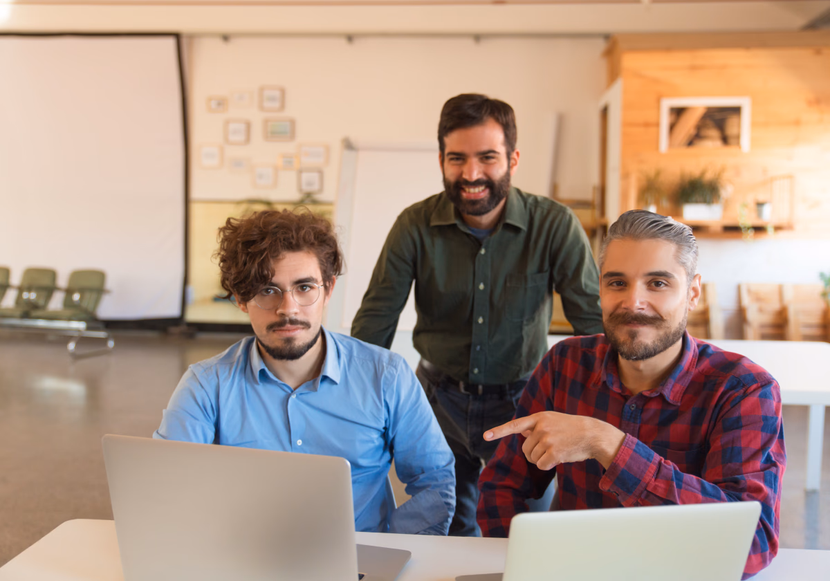 Three colleagues working together at a laptop