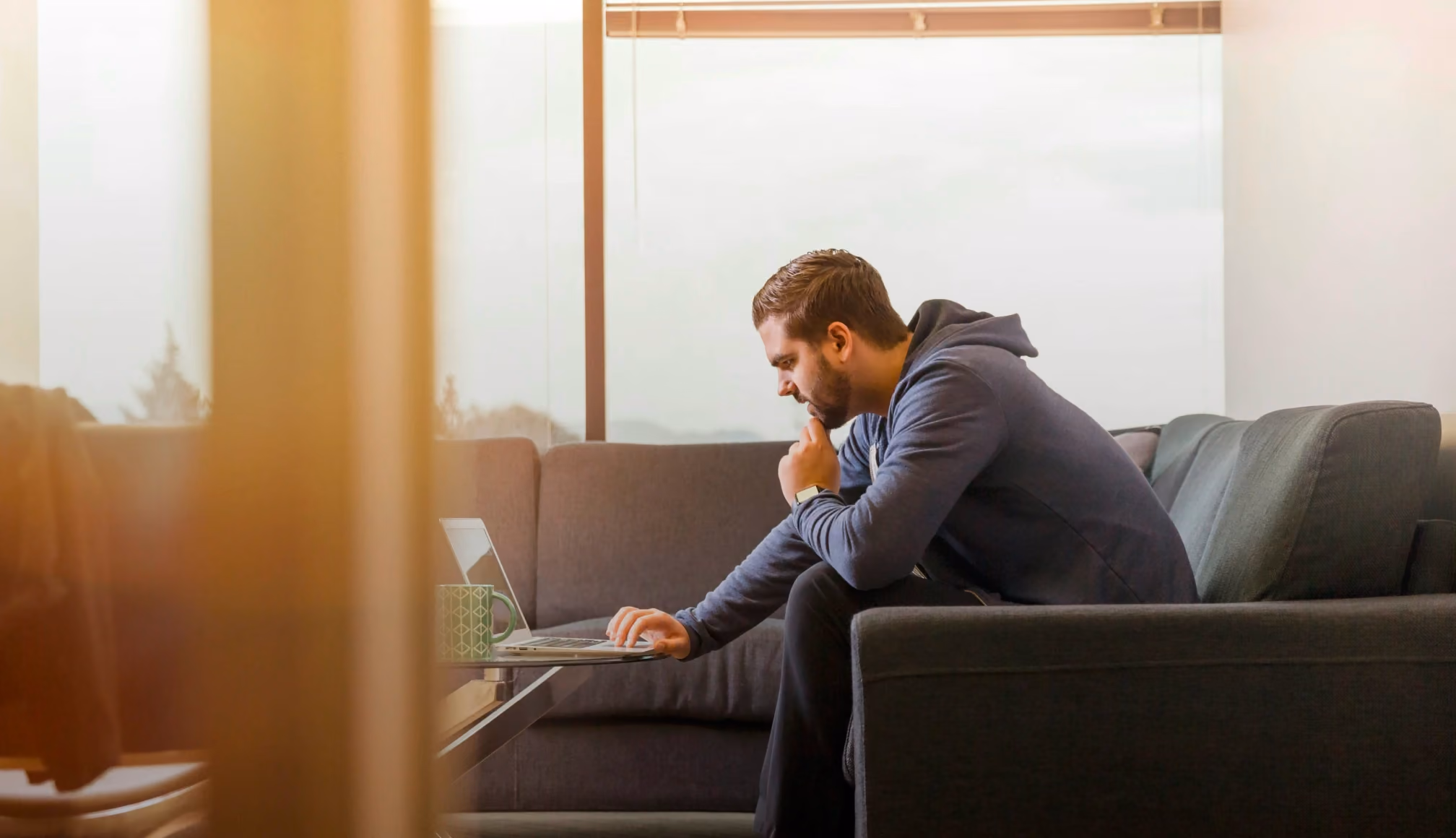 Someone working on a laptop from a couch